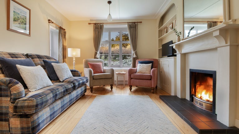 The sitting room with open fire at Old Church Lodge, Isle Of Wight